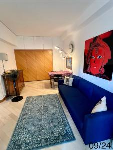 蒙特卡罗Very Central suite apartment with 1bedroom next to the underground train station Monaco and 6min from casino place的客厅配有蓝色的沙发和桌子