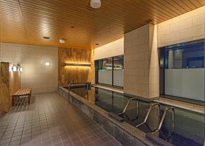 旭川旭川JR酒店的大楼内一个带长凳的游泳池
