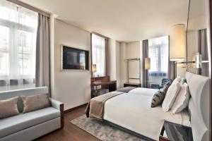 里斯本宫殿广场特里姆酒店的卧室配有白色的床和沙发