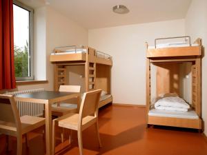 卢森堡卢森堡市青年旅舍的客房设有双层床和桌椅。