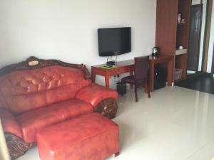努库阿洛法翡翠酒店及餐厅的客厅配有红色沙发和电视