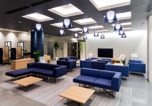 德岛德岛站前大和ROYNET酒店的一间设有蓝色沙发和电视的等候室