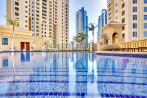 迪拜Brand new Spacious, Deluxe, 5BR plus maidroom on JBR walk Next to Beach ,Tram & Mall by La Buena Vida Holiday Homes的一座位于城市的游泳池,有高大的建筑