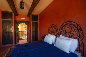 瓦尔扎扎特黑玫瑰酒店的一间卧室配有一张带蓝色床单和白色枕头的床。