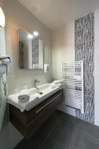 滨海萨纳里Holidays & Work HOTEL的一间带水槽和镜子的浴室