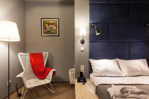第聂伯罗纽波特酒店的一间卧室配有一张床和一把椅子及红色毯子
