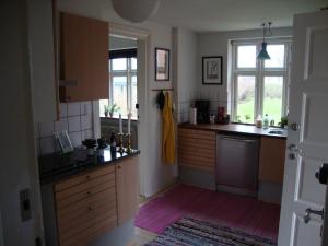 维堡Klosterpensionen Annex的厨房配有木制橱柜和窗户。