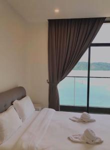 哥打京那巴鲁SummerSet Seaview Studio Apartment at Kota Kinabalu City Centre的一间卧室设有一张大床和大窗户