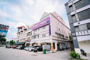 八打灵再也Swing & Pillows PJ Sunway Mentari formerly known as Swan Cottage Hotel的粉红色的建筑,旁边标有标志