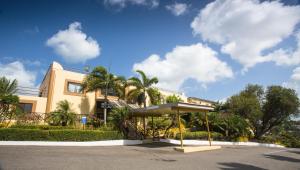 Claxton BayCara Hotels Trinidad的街道前方有棕榈树的建筑