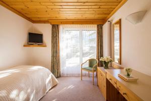 圣莫里茨莫里兹欧罗巴酒店的卧室配有床、椅子和窗户。