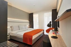 汉堡HYPERION Hotel Hamburg的配有一张床和一张书桌的酒店客房