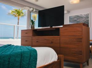 劳德代尔堡潮汐酒店的一间卧室配有大梳妆台和电视机