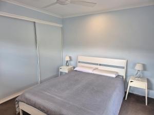 马库拉Cosy Beach Pad - Two Bedrooms的一间卧室配有一张大床和两张桌子