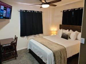 瓦莱069B Comfortable Suite with Kitchenette and King Bed near South Rim sleeps 4的一间卧室配有一张带吊扇和一张桌子的床。