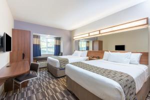 加的斯温德姆麦克罗特客栈&套房酒店的酒店客房配有两张床和一张书桌