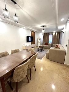 马拉喀什Charmant Appartement à Gueliz的客厅配有大型木桌和椅子