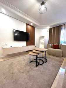 马拉喀什Charmant Appartement à Gueliz的客厅配有沙发和墙上的电视