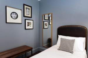 悉尼小别墅酒店的一间卧室配有一张带镜子和框架照片的床