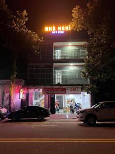 土龙木市Hotel Ngô Tình的前面有停车位的建筑