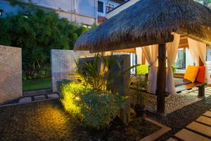 库塔巴厘岛凯迪斯别墅酒店的大伞和一些植物,建筑