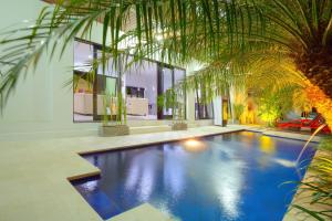 库塔巴厘岛凯迪斯别墅酒店的一座房子里棕榈树的游泳池