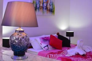 杰里科科拉卡米豪达普拉亚旅馆的一间卧室配有一张床和一张桌子上的台灯