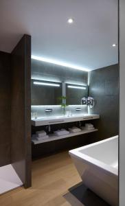 贝济耶Hôtel In Situ的浴室配有白色浴缸、盥洗盆和浴缸。