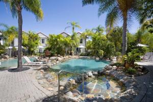 努萨维尔船长湾海滨度假酒店的一座别墅前方的棕榈树游泳池