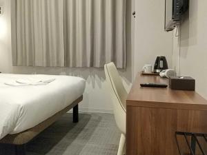 京都Smart Place Inn Kyoto Shijo Omiya Station的一间卧室配有书桌、一张床、一张桌子和椅子