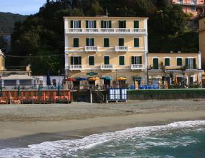 蒙特罗索阿尔马雷拜亚酒店的海滩上的一座建筑,配有椅子和遮阳伞