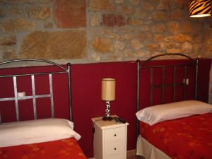 QuintanaentelloHotel La Pradera de Marta的一间卧室配有两张床和床头灯。