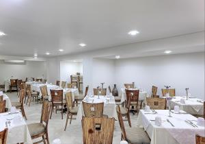 比亚埃尔莫萨Olmeca Plaza Urban Express的用餐室配有桌椅和白色的桌布