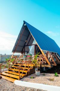 南威Unique A-Frame Cabin near to Nungwi Beach的一座带蓝色屋顶的大型建筑,设有木楼梯