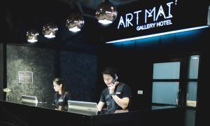 清迈Art Mai Gallery Nimman Hotel Chiang Mai - SHA Plus的坐在桌子上的男人和女人,电脑