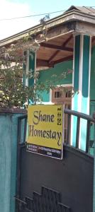 哈顿Shane HomeStay的建筑物边有房屋的标志