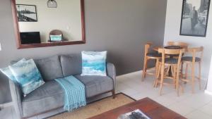 布鲁堡史特兰Cape Town Beachfront Accommodation in Blouberg的客厅配有沙发和桌子