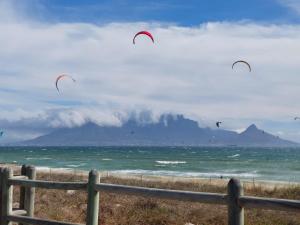 布鲁堡史特兰Cape Town Beachfront Accommodation in Blouberg的一群风筝在空中飞越海洋