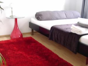 科隆班维智公寓的一间卧室配有一张床和红色地毯