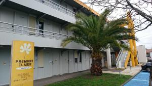 伊斯内斯普瑞米尔波尔多爱森经典酒店的一座建筑前的棕榈树