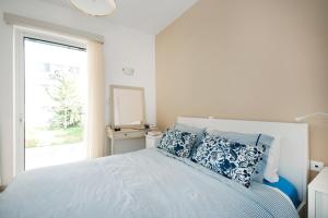罗希姆诺Apostolaki A. Apartment的一间卧室配有一张带蓝色枕头的床和一扇窗户。