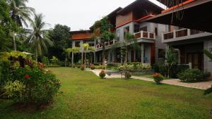 高兰Lanta Intanin Resort - SHA Extra Plus的一座带草地庭院的建筑的庭院