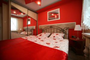 瓦乌布日赫Apartamenty Podzamcze Wałbrzych的红色的卧室,配有一张红色墙壁的床