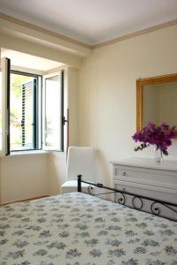 卡斯特拉巴特Residence Domus Cilento的一间卧室配有一张床、镜子和椅子