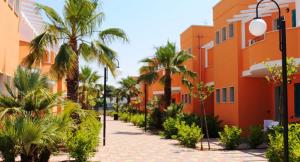 切萨雷奥港Baiamalva Resort Spa的一条种有棕榈树的街道和一座建筑