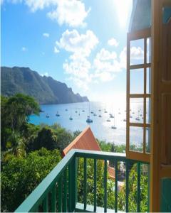 Port ElizabethTurtle Point Bequia - 4 BR Villa wstaff的阳台享有带船只的海港景色。