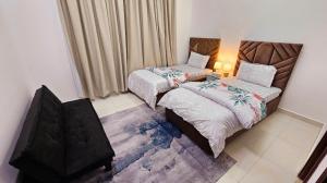 迪拜Elegant Rooms near Dubai Airport的一间卧室配有两张床和一张带台灯的桌子