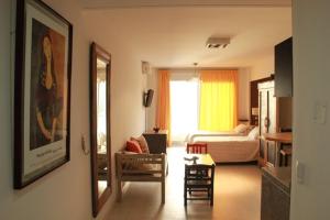 布宜诺斯艾利斯米莉诺公寓酒店的客厅设有一间卧室,配有一张床和镜子