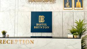 金马仑高原Hotel Brynton at Centrum的大理石墙上的蓝色标志的酒店前台