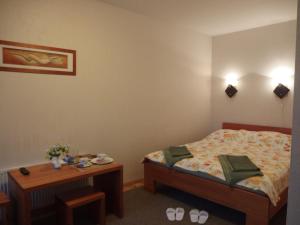 斯伽尔达公园宾馆的一间小卧室,配有一张床和一张桌子